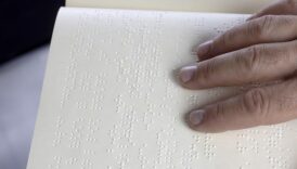 ręka osoby, która czyta tekst w alfabecie Braille'a