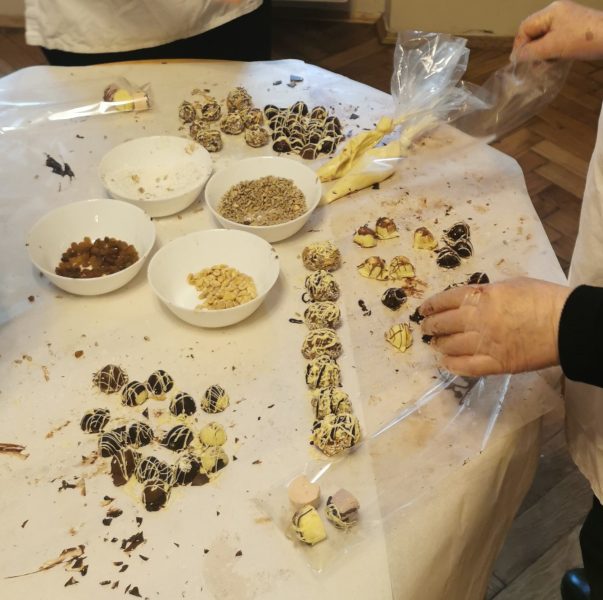Ozdabianie wypieczonych czekoladek na stole 