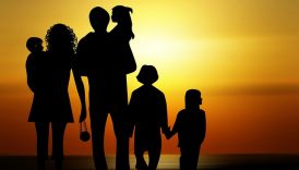 Kontur rodziny (kobieta, mężczyzna, czwórka dzieci) na tle zachodzącego słońca