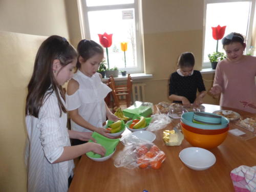 dzieci układają owoce w miskach