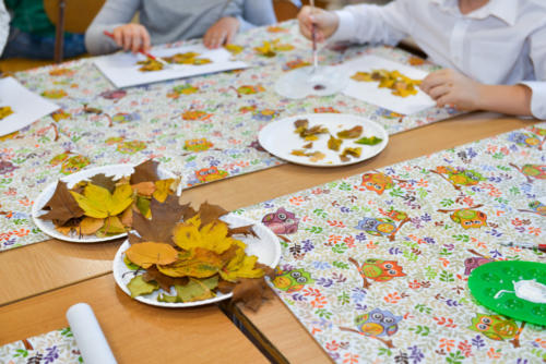 Jesienne, kolorowe liście leżą na talerzykach na stole