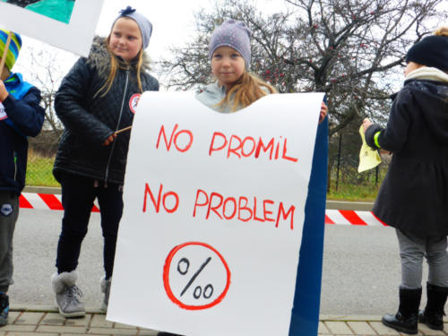 Dziecko, które na ramionach ma karton z napisem "No promil - no problem" i logo akcji