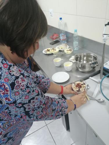 Kobieta przygotowuje deser w pucharkach