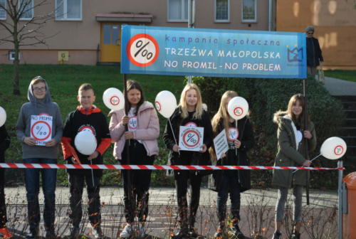 Uczniowie z transparentem z napisem "Kampania społeczna Trzeźwa Małopolska, No promil - no problem"