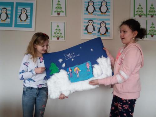 Dziewczynki prezentują plakat przedstawiający lodowisko