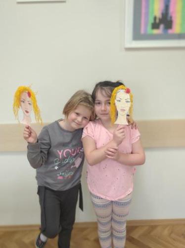 dziewczynki prezentują swoją pracę plastyczną