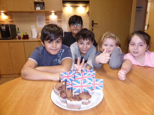 grupa dzieci pozuje na tle czekoladowych muffinek