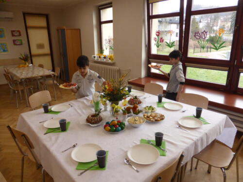 dzieci przygotowują stół wielkanocny