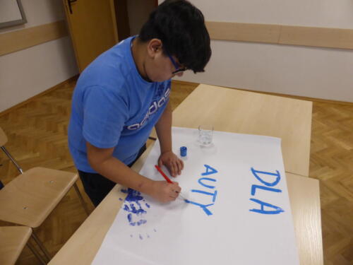 Chłopiec wykonuje napis "Dla autyzmu"