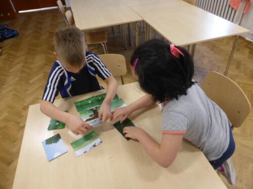 Dziewczynka i chłopiec układają puzzle