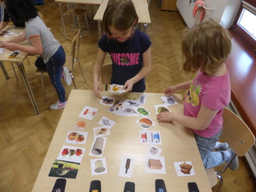 Dzieci układają rysunki śmieci przy odpowiednich pojemnikach do segregacji odpadów