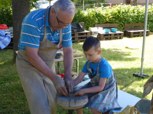 prowadzący pokazuje chłopcu, jak zrobić naczynie na kole garncarskim