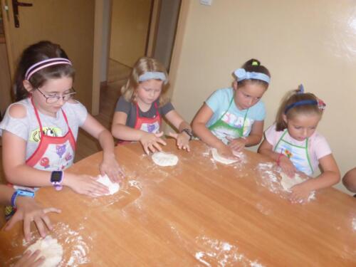 Dzieci wyrabiają ciasto na pizze