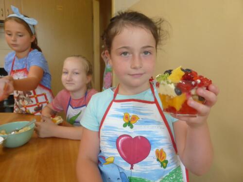 Dziewczynki układają składniki w pojemniczka na deser