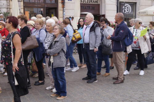 Seniorzy stoją na Rynku Głównym w Krakowie