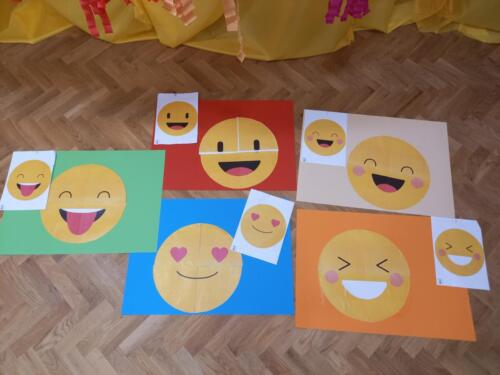 Praca wykonana przez dzieci – sklejone puzzle emotikonek na dużych arkuszach papieru