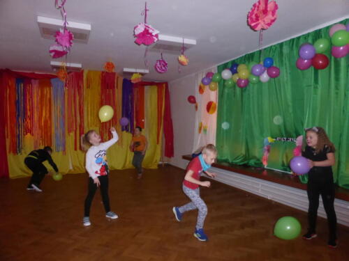 Dzieci bawiące się balonami podczas balu karnawałowego 
