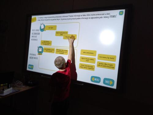 Chłopczyk korzysta z tablicy interaktywnej