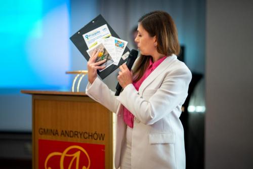 Kierownik Działu Profilaktyki Środowiskowej Ośrodka Pomocy Społecznej w Andrychowie Marta Kajzer pokazuje ulotki dotyczące oferty Ośrodka Pomocy Społecznej