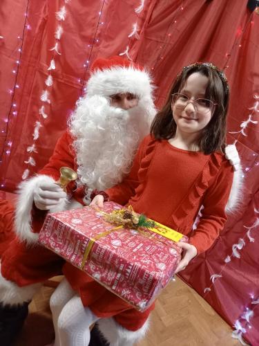dziewczynka pozuje do zdjęcia ze świętym Mikołajem