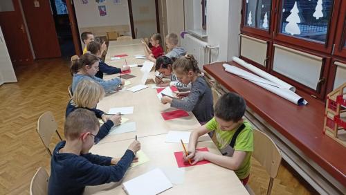 Dzieci odrysowują swoje dłonie na kartkach