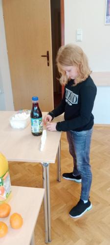 dziewczynka układa kostki cukru przy butelce z napojem