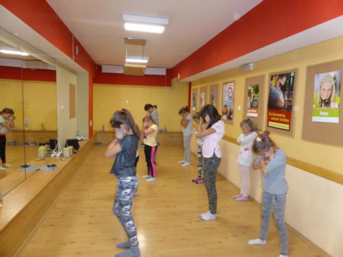 Dzieci wykonujące ćwiczenia przed lustrem.