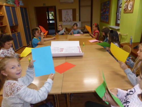 Dzieci wycinają coś z kolorowych kartek