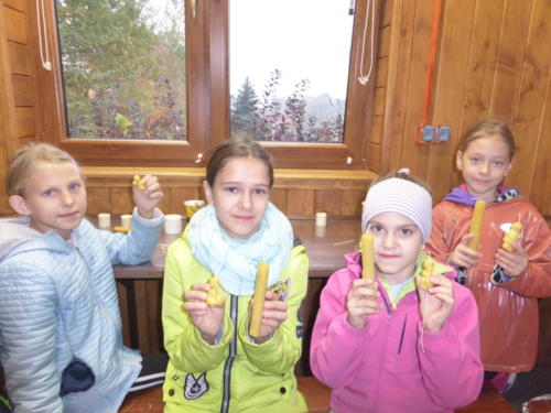 Dziewczynki trzymają świeczki z wosku pszczelego