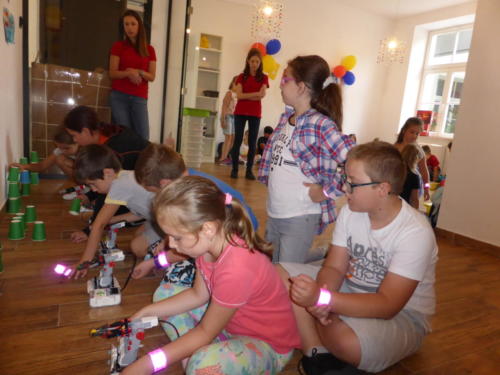 dzieci bawią się robotami zrobionymi przez nie z klocków lego