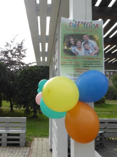 Zdjęcie plakatu zapraszającego na "Dwie godziny dla Rodziny", ozdobionego balonami