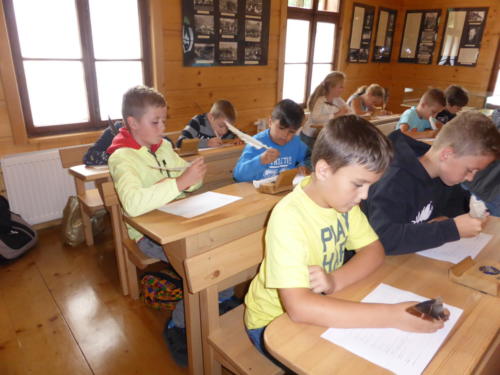 Dzieci uczące się pisać gęsim piórem