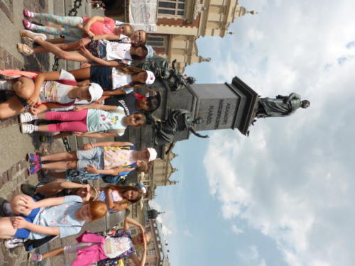 Zdjęcie grupowe dzieci przed pomnikiem Adama Mickiewicza w Krakowie