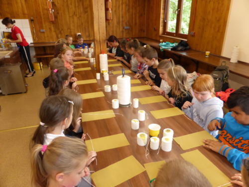 dzieci wykonują świece z wosku pszczelego
