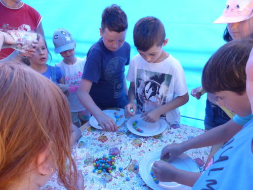 dzieci przeprowadzają eksperyment z wykorzystaniem kolorowych cukierków