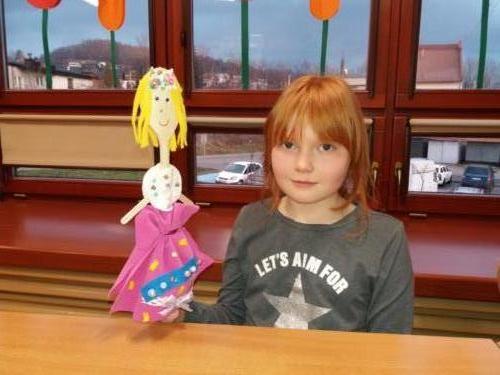 Dziewczynka prezentująca wykonaną przez siebie lalkę.