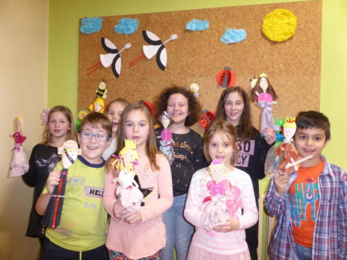 Dzieci prezentujące lalki  wykonane z drewnianych łyżek.