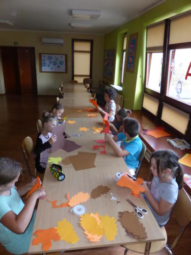 Dzieci wycinają liście z kolorowego papieru
