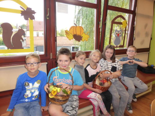 Dzieci z koszami pełnymi darów jesieni